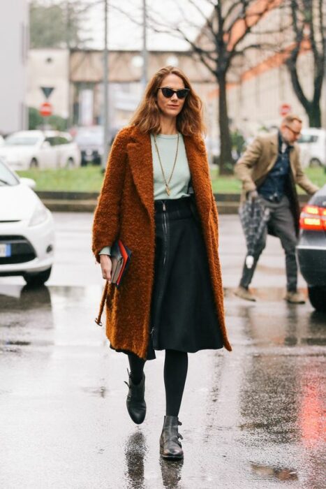 mujer caminando por la calle usando una gabardina café 