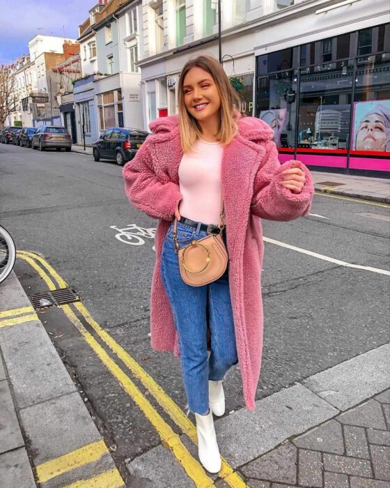 mujer posando con una gabardina de borrega tino lana en color rosa pastel 