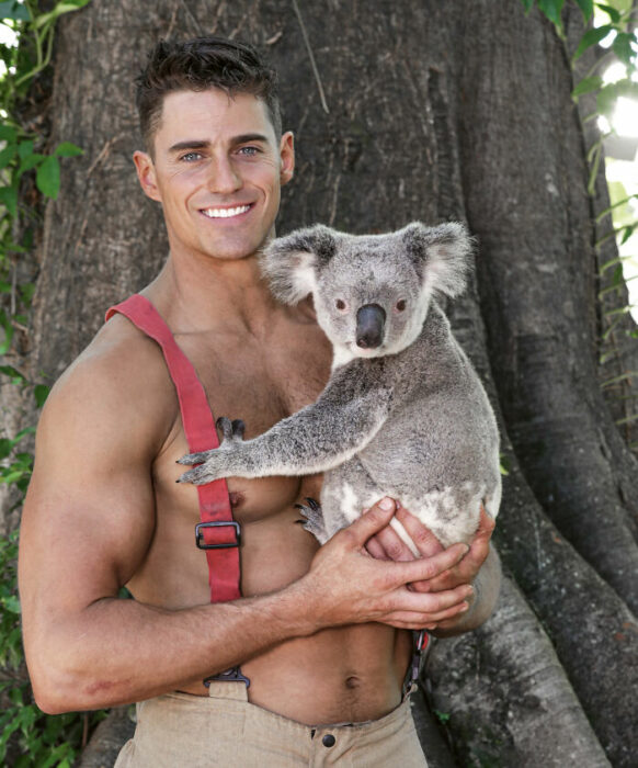 firefighter poses for charity calendar with a koala