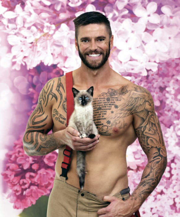 firefighter posing for charity calendar with a kitten in his hand