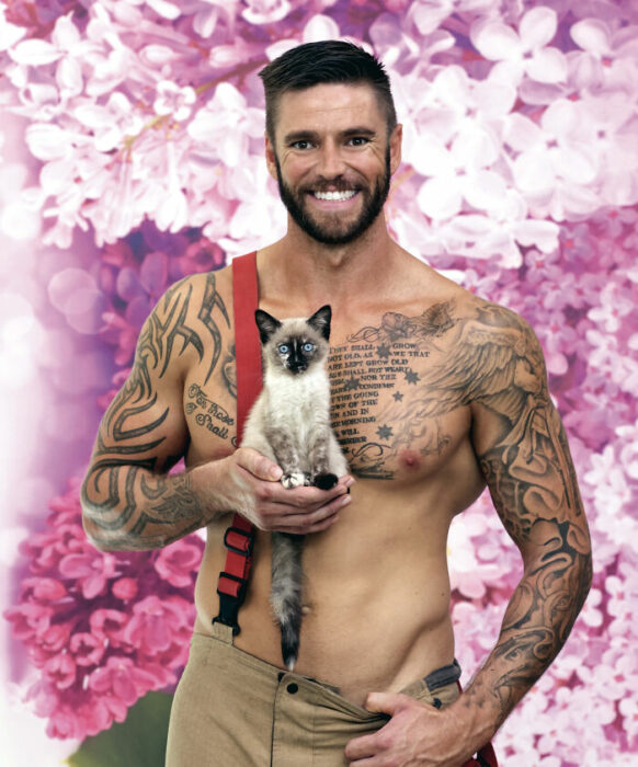 bombero posando para calendario benéfico con un gatito en la mano