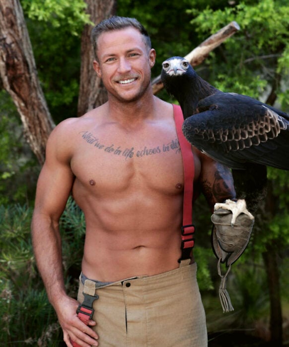firefighter posing for charity calendar with a bird 