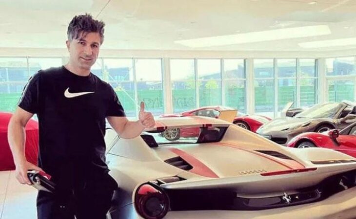 hombre posando en una agencia de autos lujosos, vestido con playera negra de la marca nike y pantalones negros