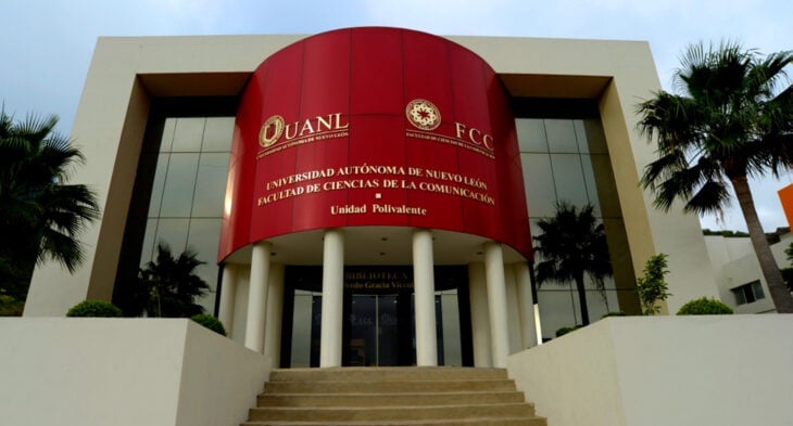 fachada de una Facultad pintada en color rojo y crema, con letras doradas y ventanales de doble altura