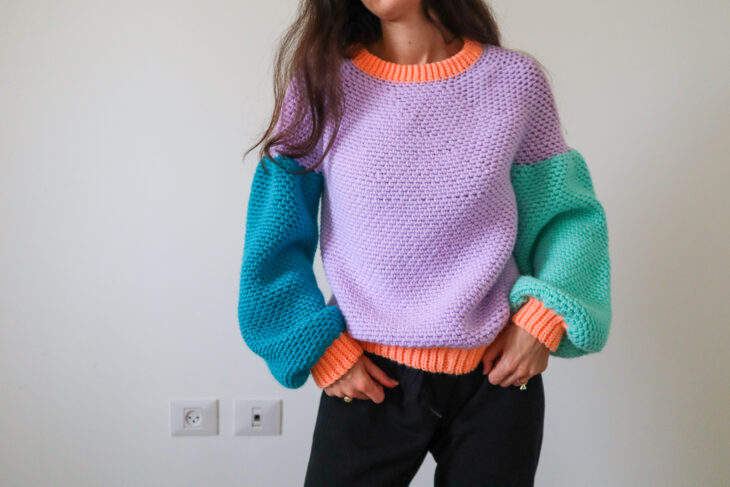 Mujer con suéter cardigan de tejido crochet morado, verde y azul