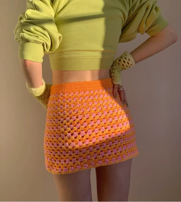 Mujer usando falda naranja de tejido crochet