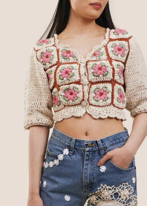 Mujer con crop top de tejido crochet con flores
