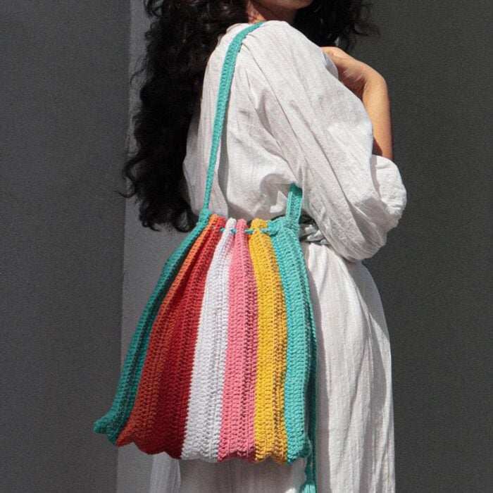 Mujer usando bolsa al hombro de tejido crochet colorida