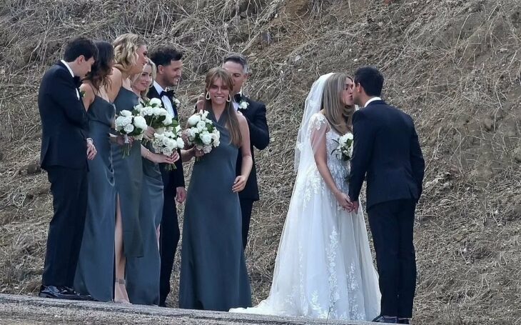 Photograph showing Taylor Lautner at his wedding kissing his wife in front of the bridesmaids 