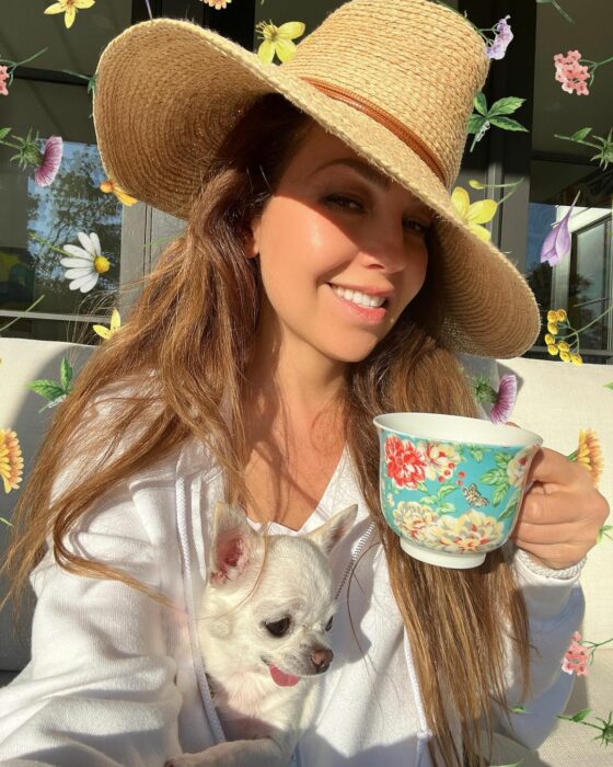 Selfie of Thalía with a cup of coffee with her apple-headed Chihuahua dog