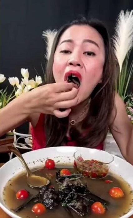 chica tailandesa comiendo un murciélago 