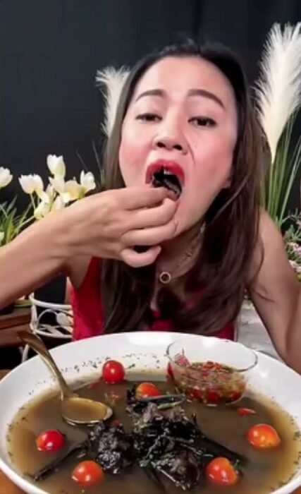 chica tailandesa comiendo un murciélago 