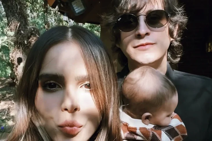 Yuya y Siddharta se fotografiaron junto a su pequeño hijo, la pareja mira de frente a la cámara , el cantante trae unos lentes oscuros y carga a su hijo en brazos 