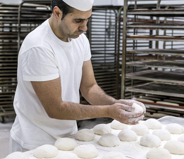 Panadero elaborando bollos de pan 