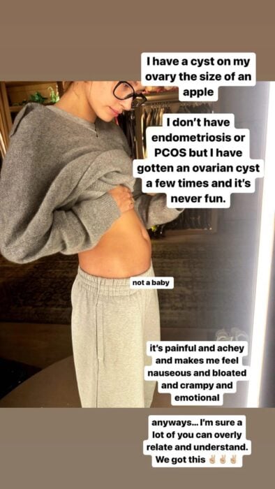Selfie of Hailey Bieber in front of the mirror lifting her shirt to show her stomach and reveal that she has a cyst on her ovary the size of an apple