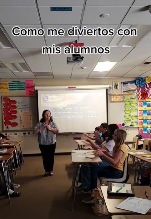 maestra de california en salon de clases enseña español con canción de Espinoza Paz