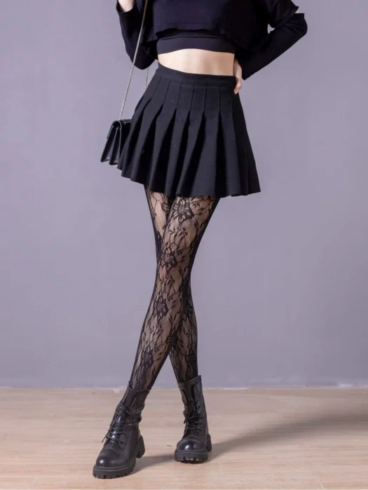 Woman's legs in black skirt and black stockings with flower-shaped lace pattern