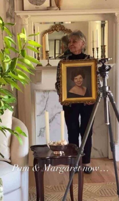 señora mayor sosteniendo el retrato de una amiga difunta
