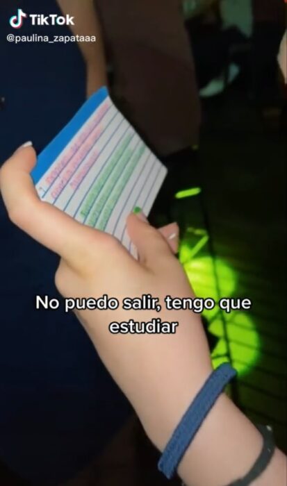 mano de mujer sosteniendo notas de estudio