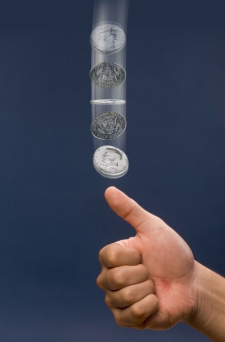 Hand tossing coin in the air