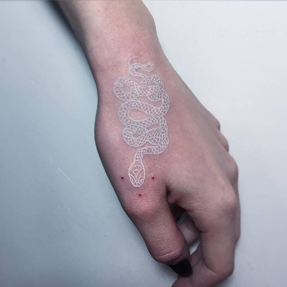mano con tatuaje de serpiente en color blanco