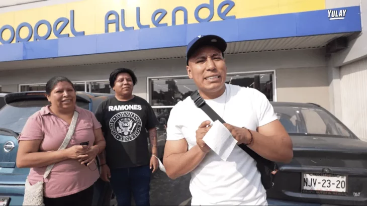 tres personas en el exterior de la tienda departamental Coppel uno de ellos esta vestido con playera blanca y lleva una cachucha, también aparece en la foto un hombre y una mujer vestidos de forma informal