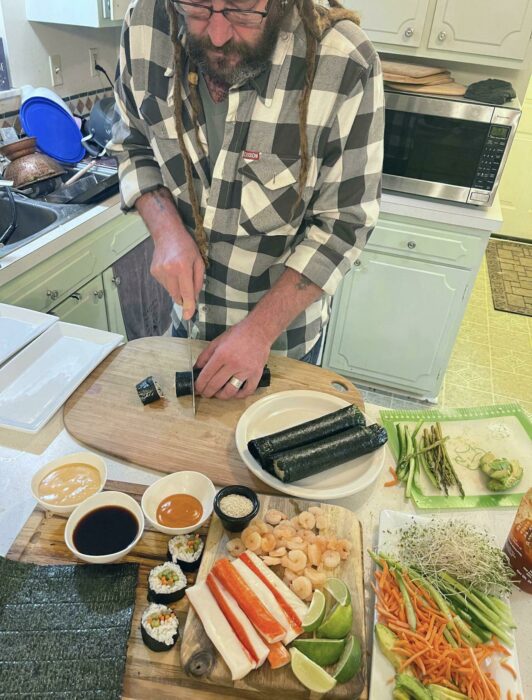 hombre en la cocina preparando Sushi 