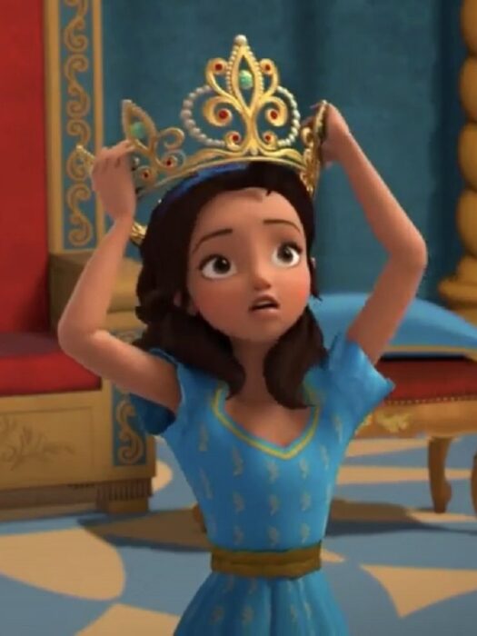 imagen de la serie animada Elena of Avalor la princesa está sosteniéndose una corona dorada lleva un vestido azul cielo y está en un castillo