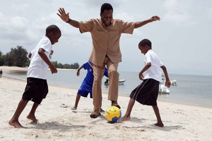 Pelé jugando futbol en la playa con unos niños 