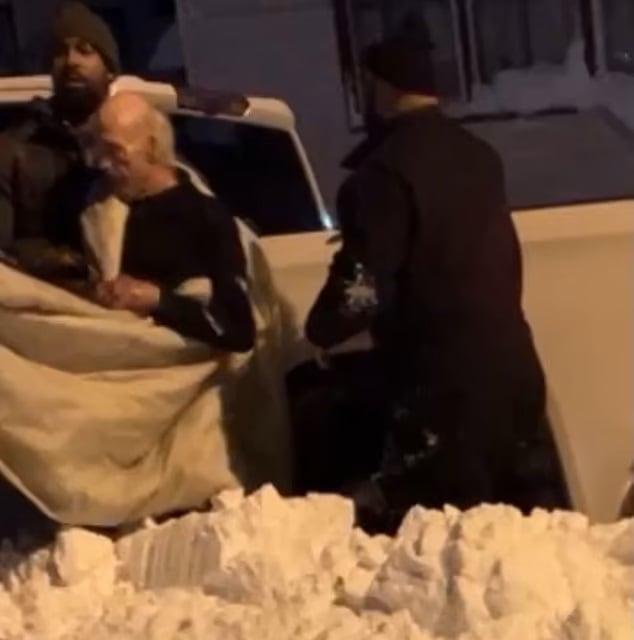 Personas cargando a Joey White para llevarlo al hospital en un auto