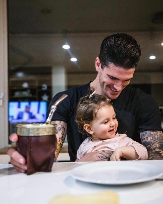 Rodrigo de Paul sentado con playera negra y su hija