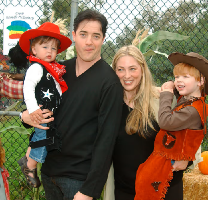 Brendan Fraser en una imagen con su ex esposa Afton Smith llevan en brazos a dos de sus hijos todavía pequeños los niños están vestidos de vaqueros y sus padres visten casual en color negro