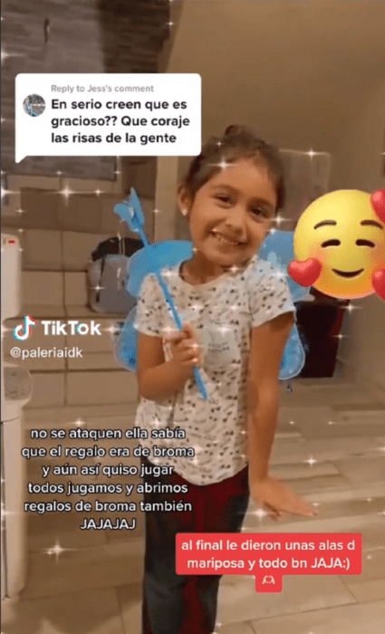 niña sonriendo en una imagen de TikTok lleva una barita mágica de juego y unas supuestas alas de mariposa azules esta sonriendo feliz