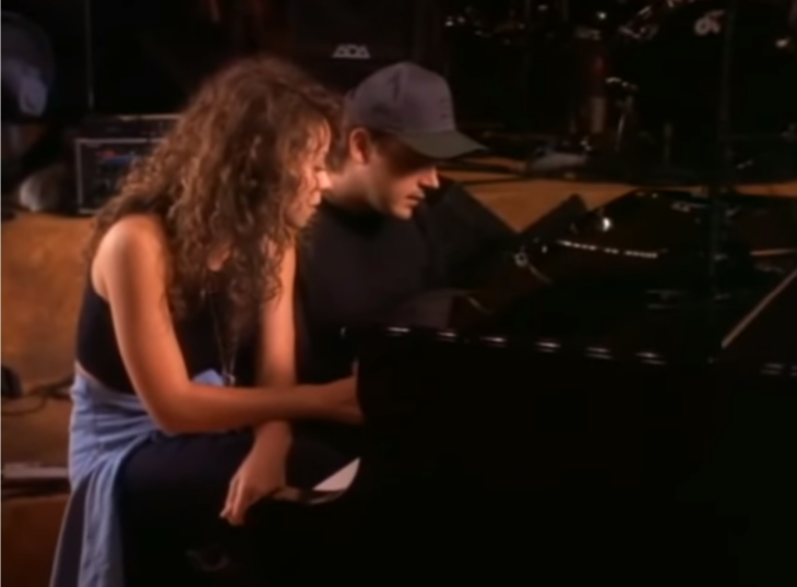 la cantante Mariah Carey junto al productor Walter componiendo una canción frente a un piano negro ambos llevan ropa informal 