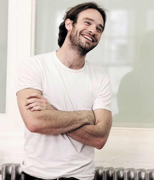 Charlie Cox posando con playera blanca