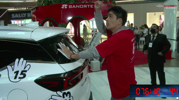 imagen que muestra a un hombre con la mano sobre una camioneta en un centro comercial de Monterrey donde se ganó el automovil 