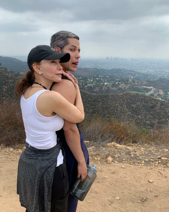 Mamá de Christian Chávez abrazandolo mirando hacia el horizonte en lo alto de una montaña 