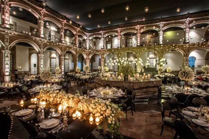 un salón elegante adornado con flores y velas toda la decoración lista para una boda de ensueño 