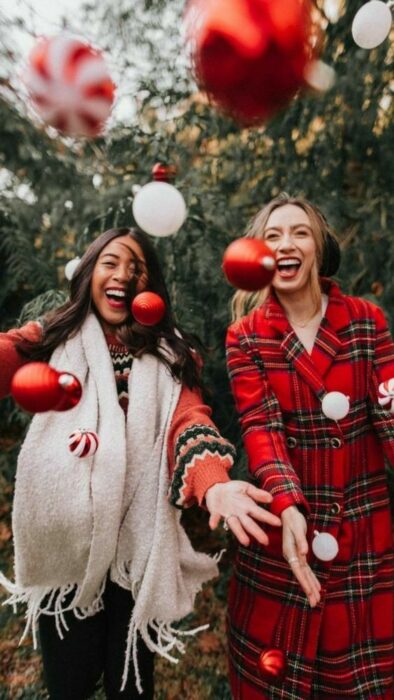 Dos amigas lanzando esferas navideñas