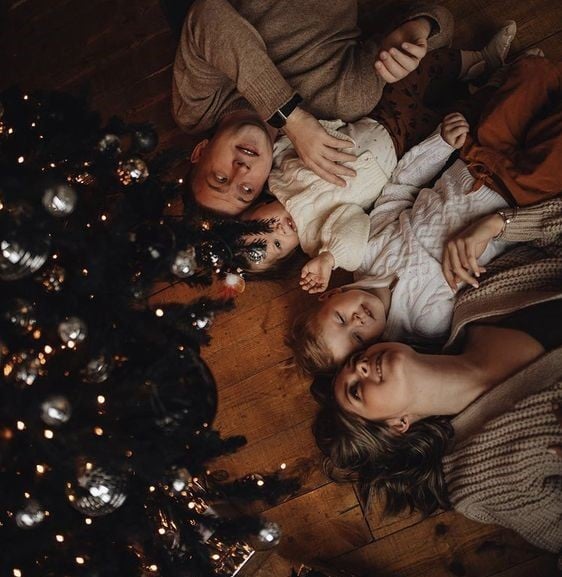 Familia posando junto al árbol de navidad