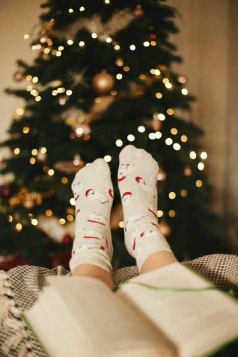 Foto de pies frente al árbol navideño