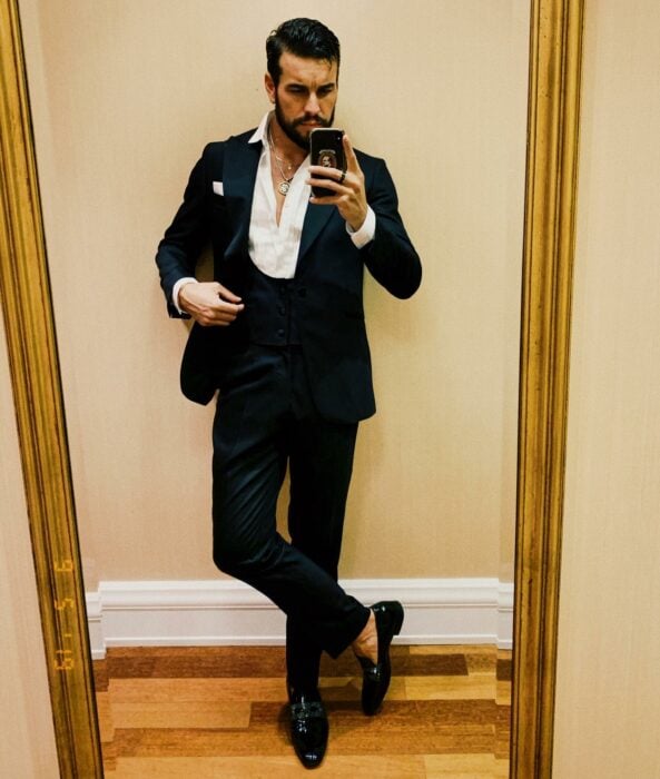 Mario Casas tomándose una fotografía vestido de traje frente al espejo 
