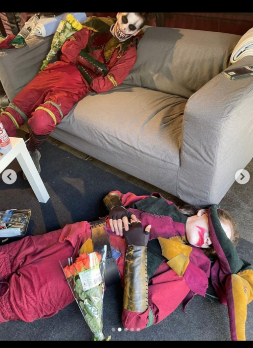 fotografía de un par de personas acostadas en el sofá y en el suelo disfrazados de arlequines 