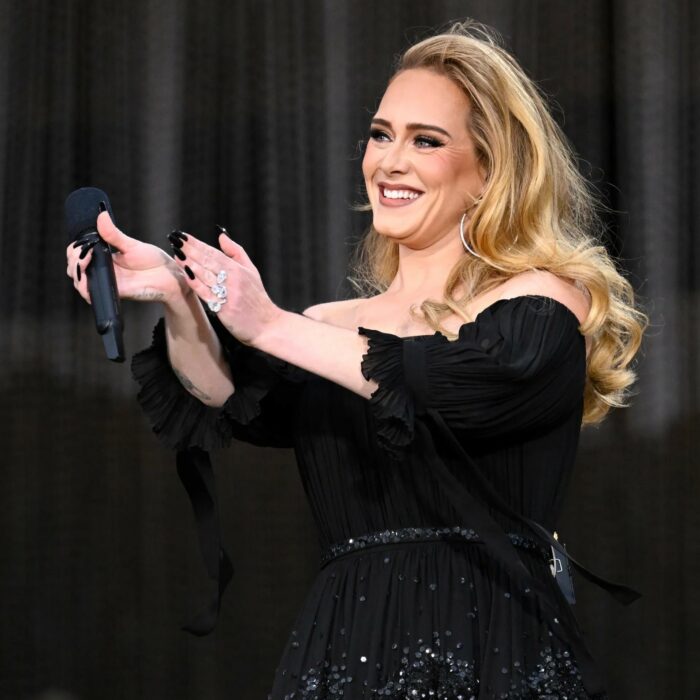 Adele aplaudiendo y sonriendo en uno de sus conciertos 