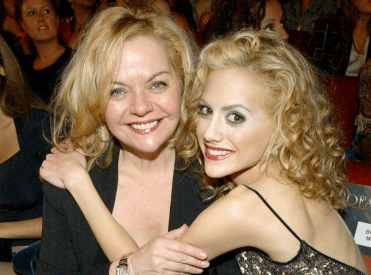 Sharon y Brittany Murphy están sentadas posando para la cámara ambas sonríen y están disfrutando de algún evento llevan maquillaje casual