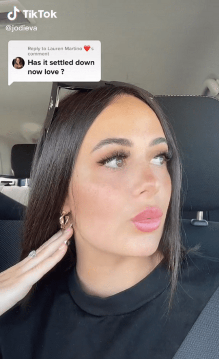 image of a girl who has straight black hair with a fair complexion is wearing false eyelashes and low-key makeup is turning to a point away from the camera