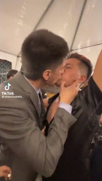 captura de pantalla del video viral en el que un invitado besa al novio en plena boda 