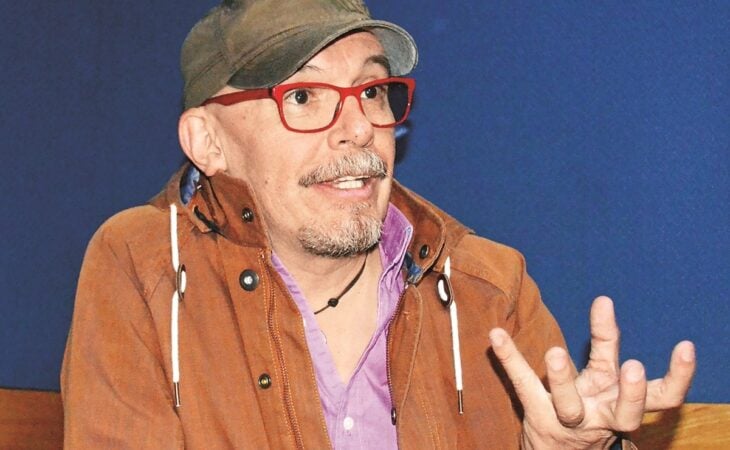 el comediante Mauricio Castillo en una entrevista trae una cachucha verde y una chamarra café lleva lentes transparentes 