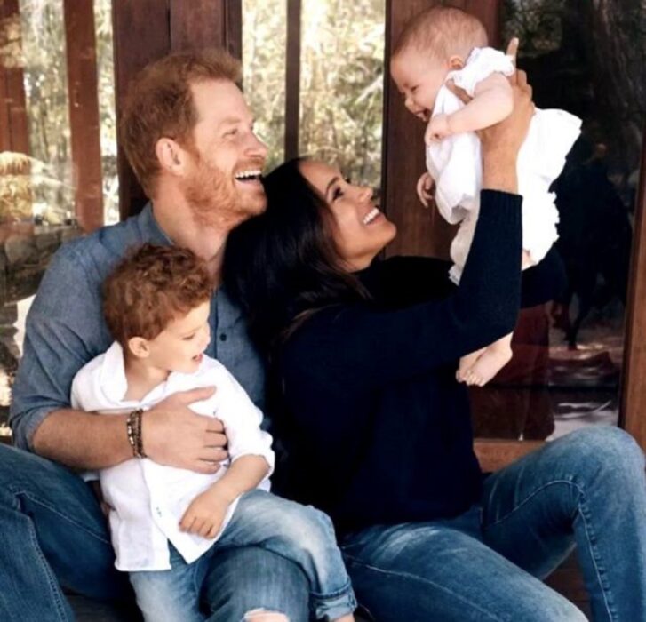 la familia de los duques de Sussex: Harry y Meghan Markle sostienen felices a sus hijos en brazos ella carga a la niña y él trae al pequeño 