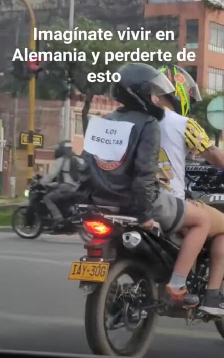 captura de pantalla de un video que muestra a un par de chicos a bordo de una moto escoltando a un carro 